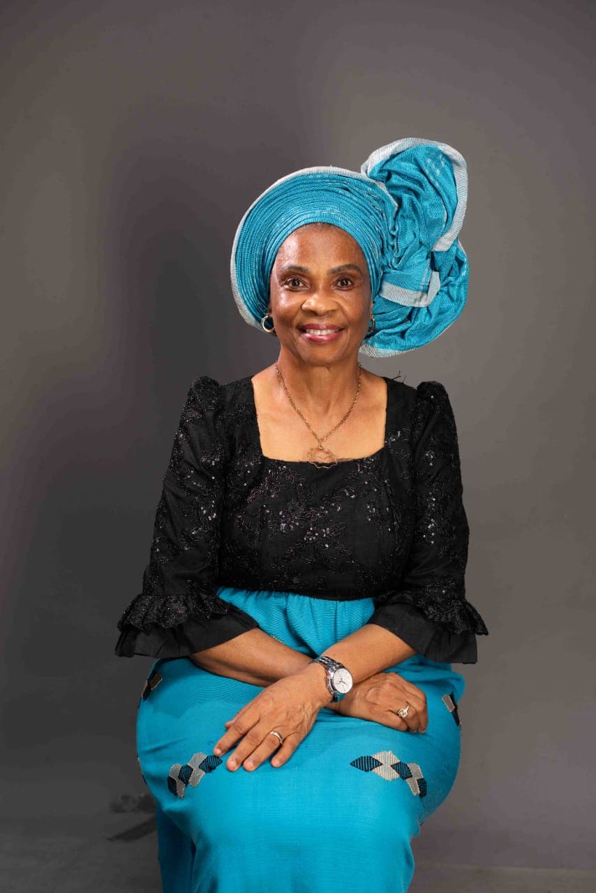 Ambassador Nkoyo Esu Toyo seated, wearing a blue gele and black lace blouse